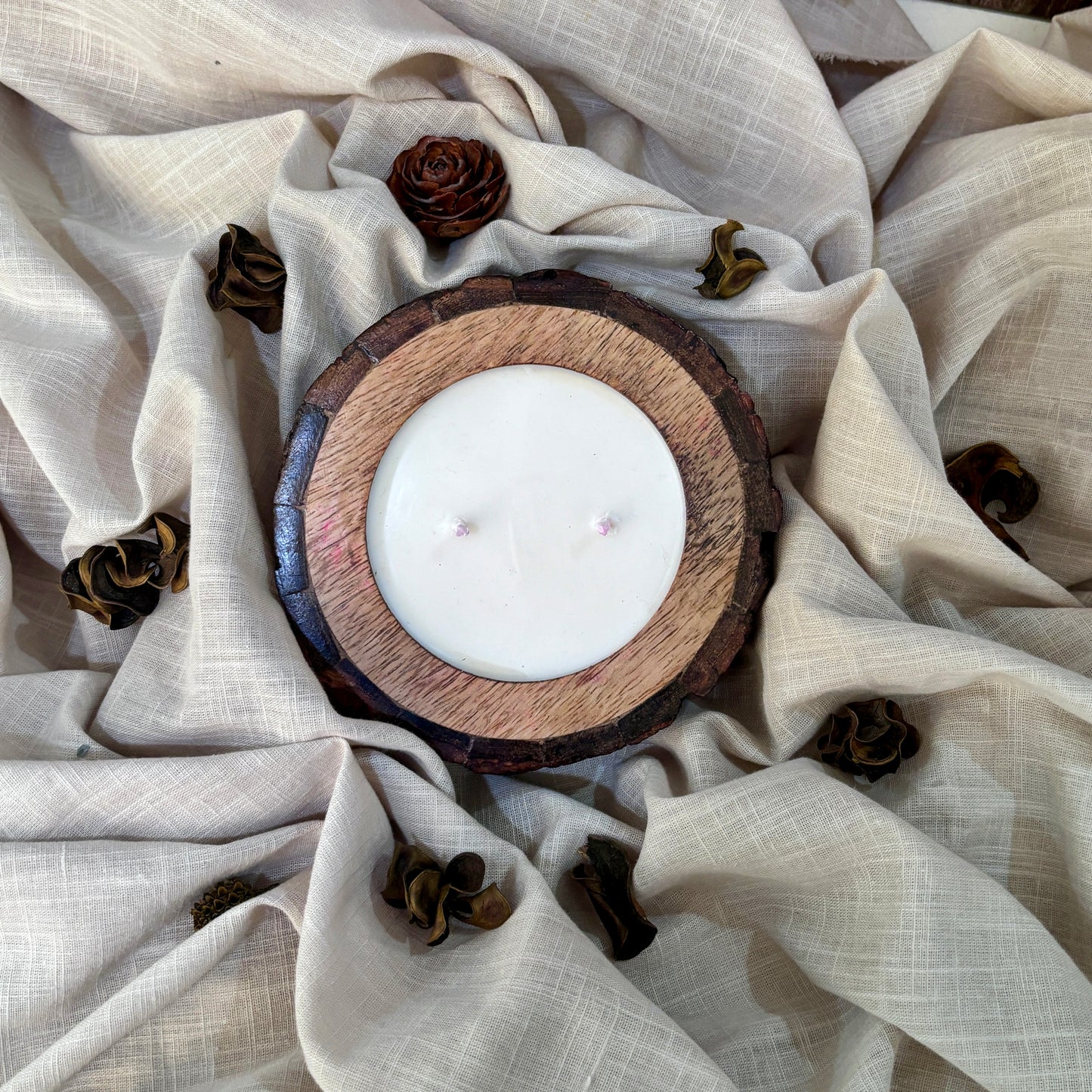 Organic wax candle in a rustic wooden bark bowl