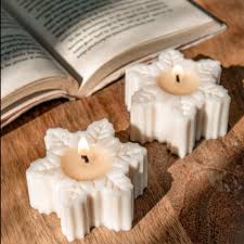 Handcrafted snowflake candle casting a warm, festive glow