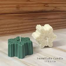 Snowflake-shaped candle with intricate frosty details, softly glowing in a cozy winter setting